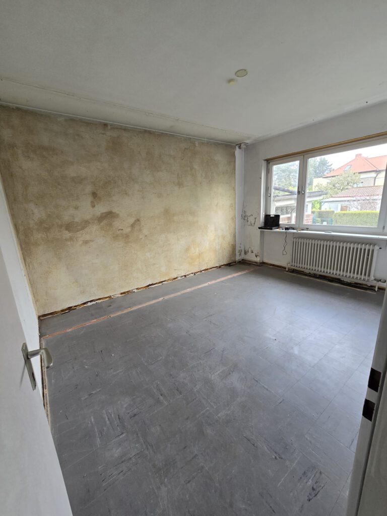 Zweites Zimmer – nach kompletter Möbel- und Teppichentfernung → Bodenplatten freigelegt, Fläche besenrein übergeben.