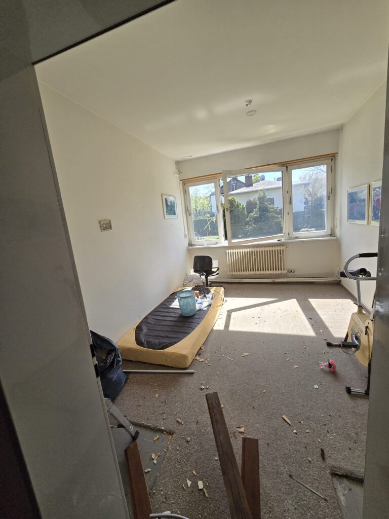 Schlafzimmer – Zustand vor der Räumung → Verschmutzter Teppichboden, Deckenlampe und Wanddeko noch vorhanden