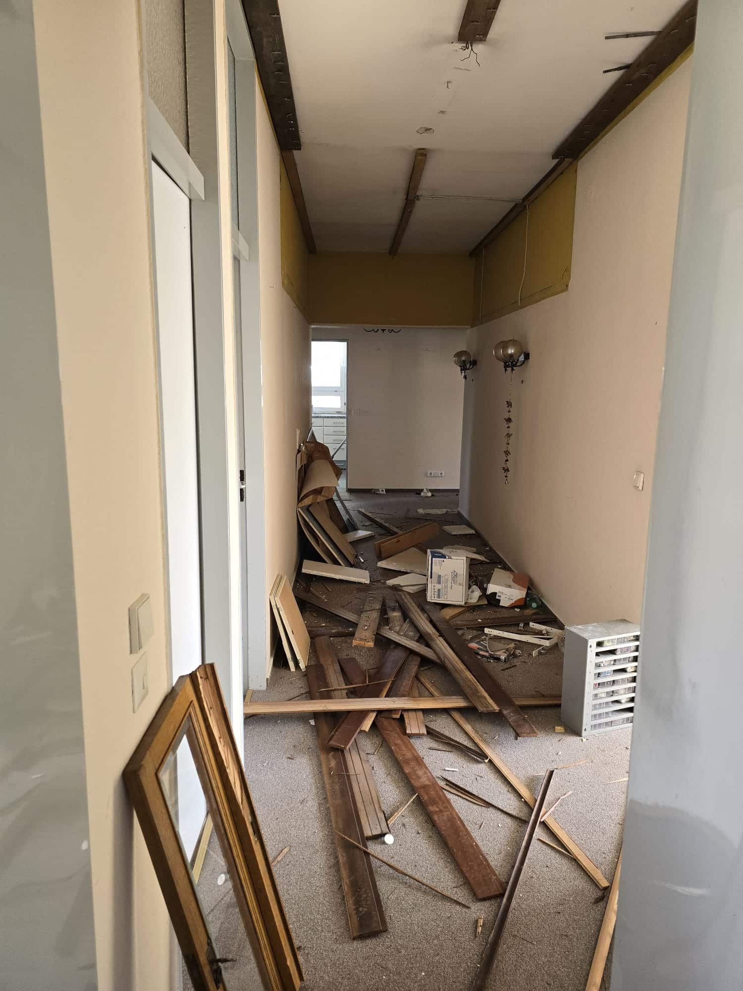 Wohnungsauflösung Dallgow – langer Flur vollgestellt mit Holzresten vor der Entrümpelung